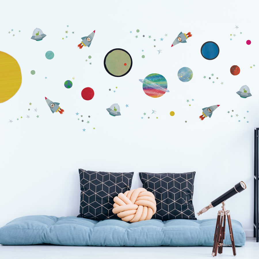 space adventure wall sticker pack shown on a light coloured wall behind a blue futon with black pillows
