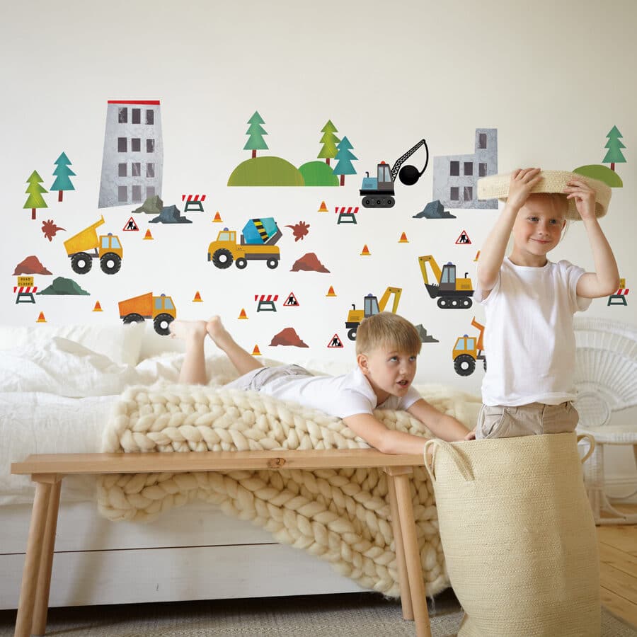 construction wall sticker pack shown on a light coloured wall behind two young boys playing