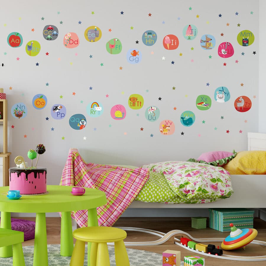 alphabet wall sticker pack large shown on a light coloured wall behind a colourful bed