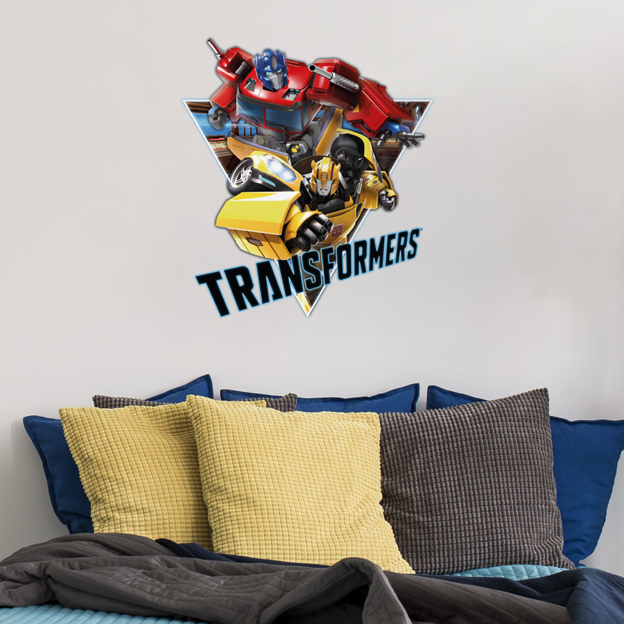Transformers triangle wall sticker shown on a white wall behind a sofa with yellow and blue pillows