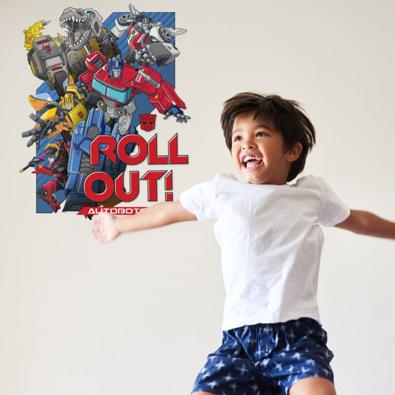 Transformers roll out wall sticker regular shown on a light beige wall behind a young boy jumping