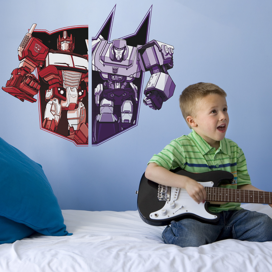 Optimus VS Megatron wall sticker shown on a light blue wall behind a child playing guitar
