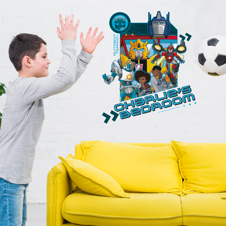 personalised transformers wall sticker shown on a light coloured wall behind a yellow sofa