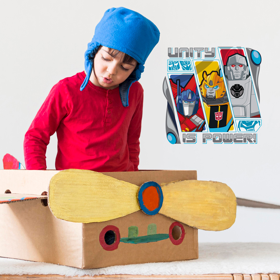 Transformers unity wall sticker shown on light coloured wall behind a child playing in a cardboard box
