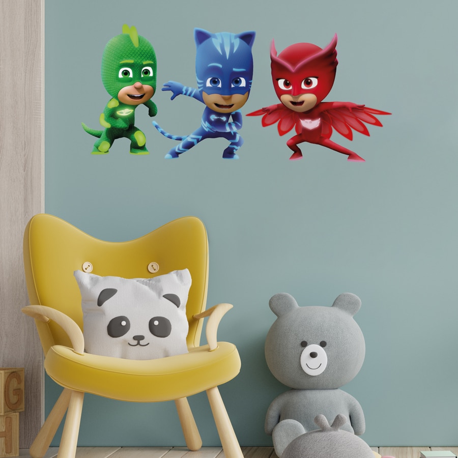 PJ masks team wall sticker large shown on a grey blue wall behind a yellow chair