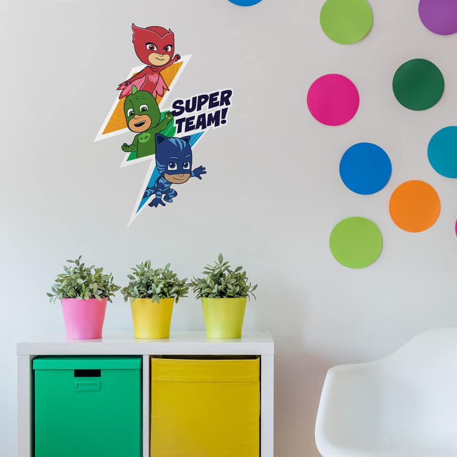 super team wall sticker shown on a white wall behind colourful drawers