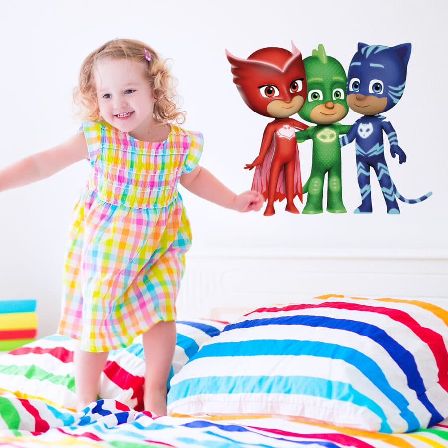 Hero friends wall sticker large shown on a white wall behind a girl jumping on a rainbow coloured bed