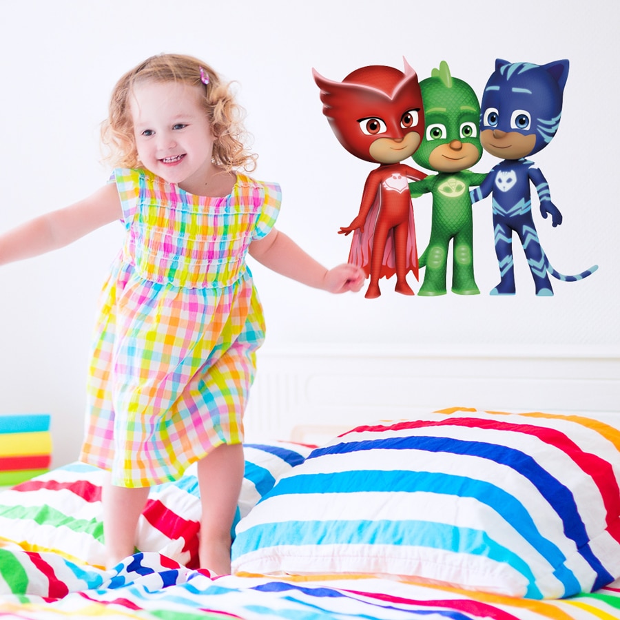 Hero friends wall sticker large shown on a white wall behind a girl jumping on a rainbow coloured bed