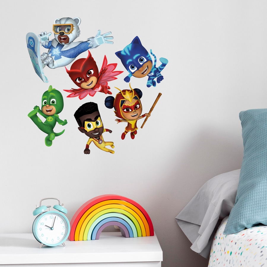 power heroes group wall sticker regular shown on a light coloured wall behind a white chest of drawer with a wooden rainbow and blue alarm clock