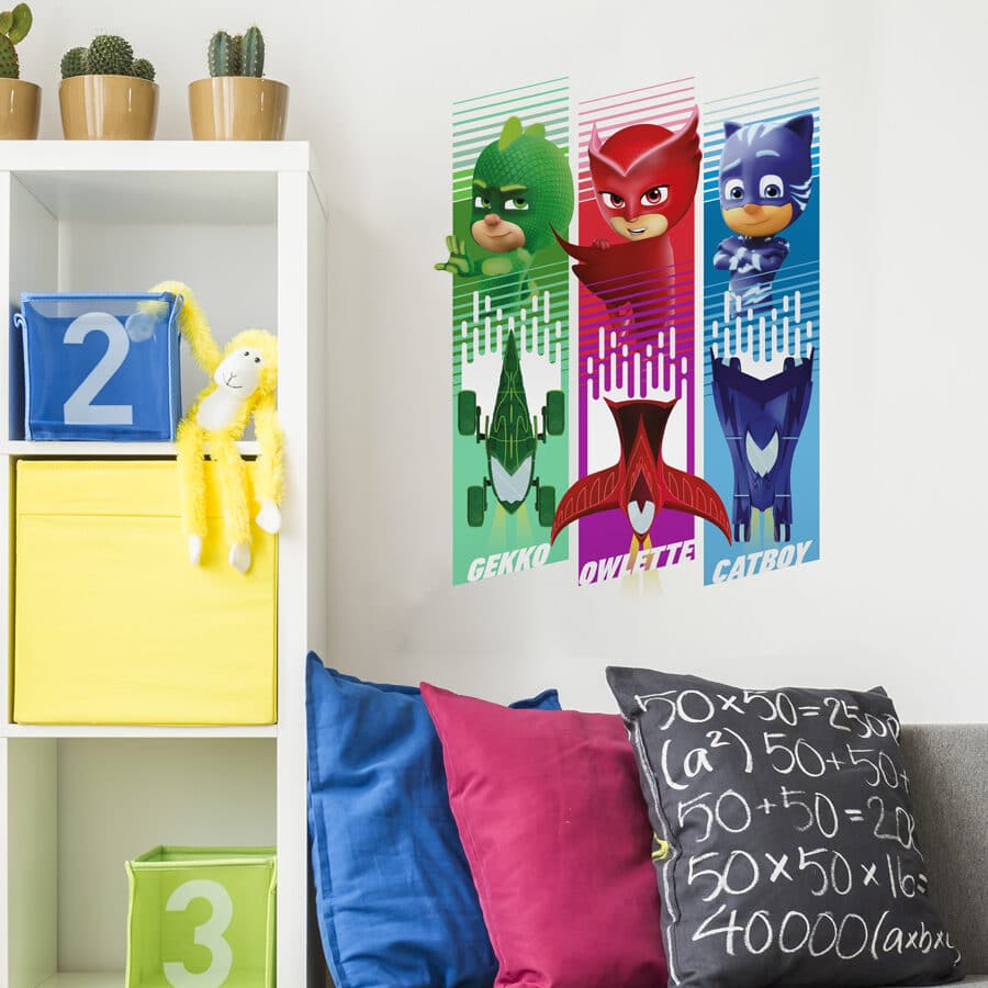 PJ Masks vehicles wall sticker shown on a white wall behind a sofa with red, blue and black pillows