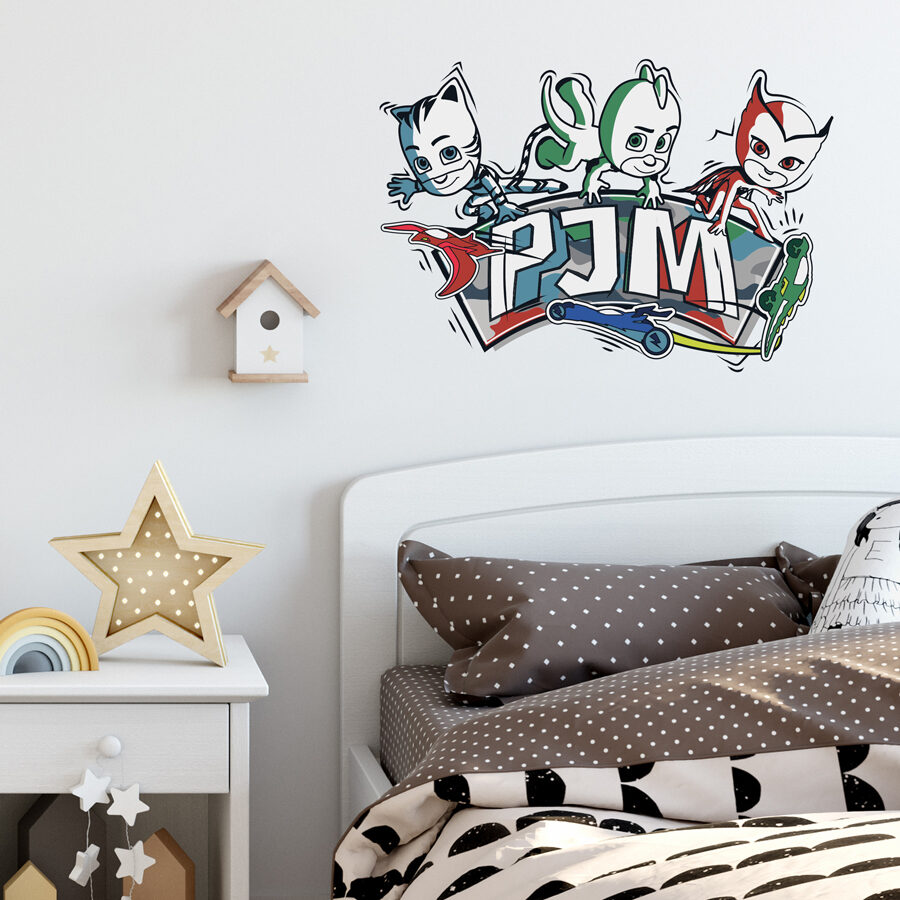 PJ Masks doodles wall sticker shown on a bedroom wall above the headboard of a white bed with brown and cream bedding