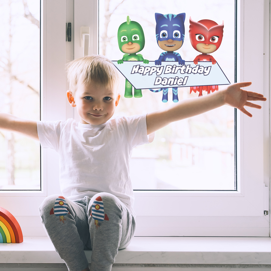 PJ Masks birthday window sticker regular on a window behind a boy