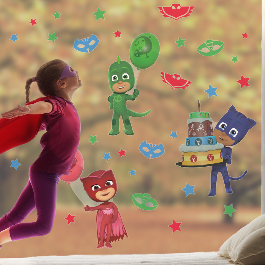 PJ Masks party window stickers large shown on a window behind a girl dressed as a superhero