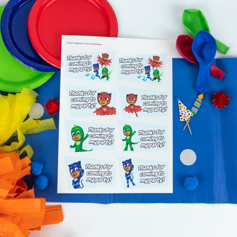 PJ Masks Party Bag Label Pack option 1 label sheet shown on a table decorated for a party