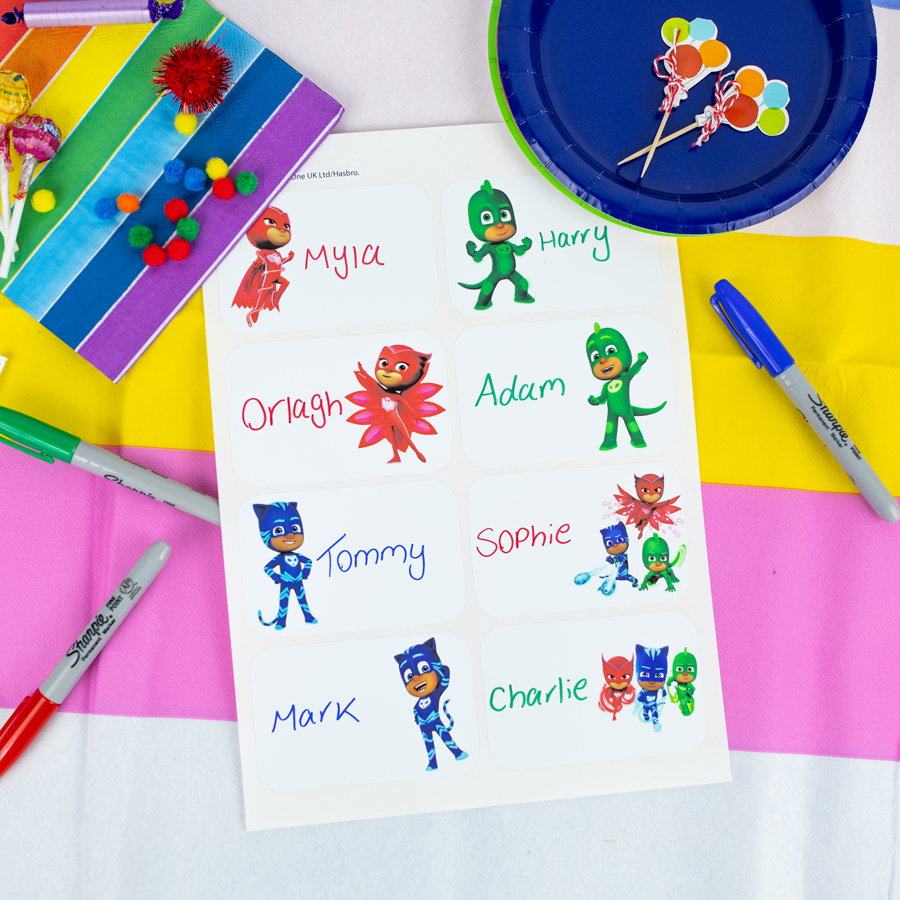 PJ Masks birthday label pack option 1 sheet shown on a table decorated for a party