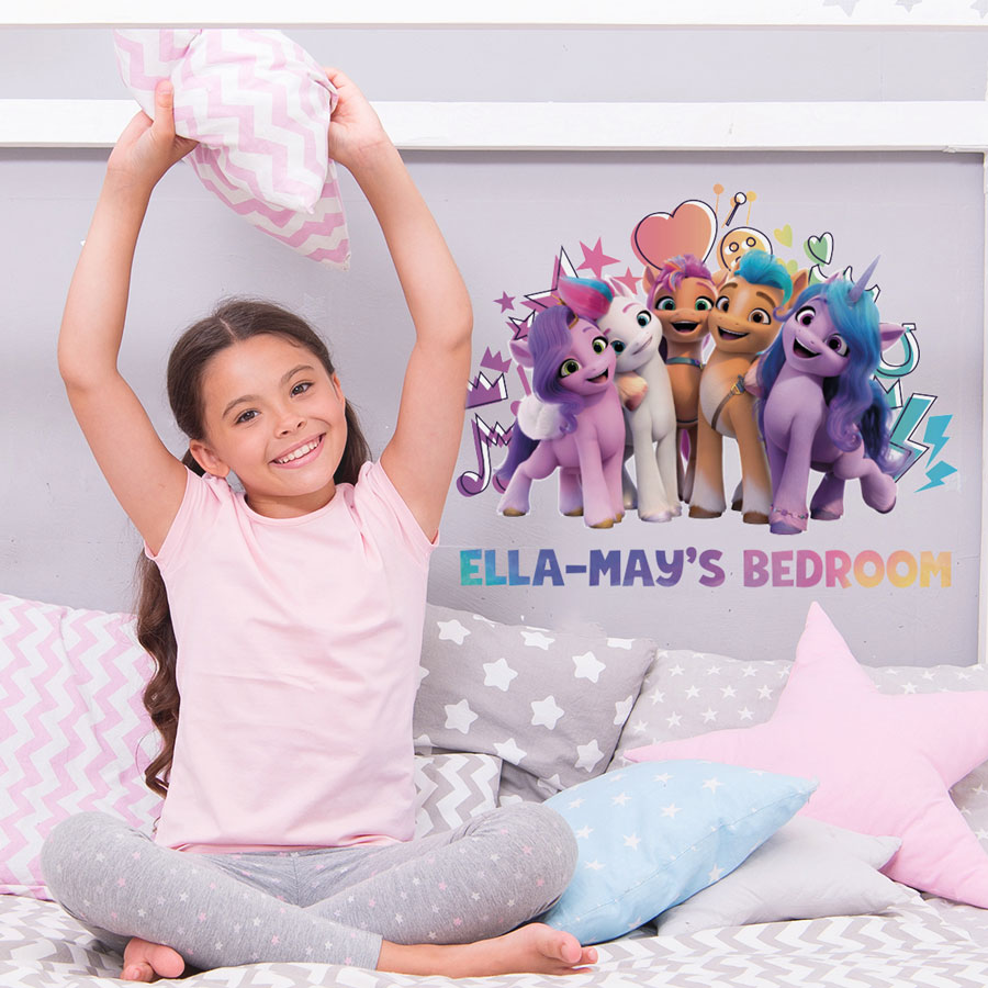 Personalised My Little Pony wall sticker regular shown on a grey wall behind a child sat on a grey and pink bed