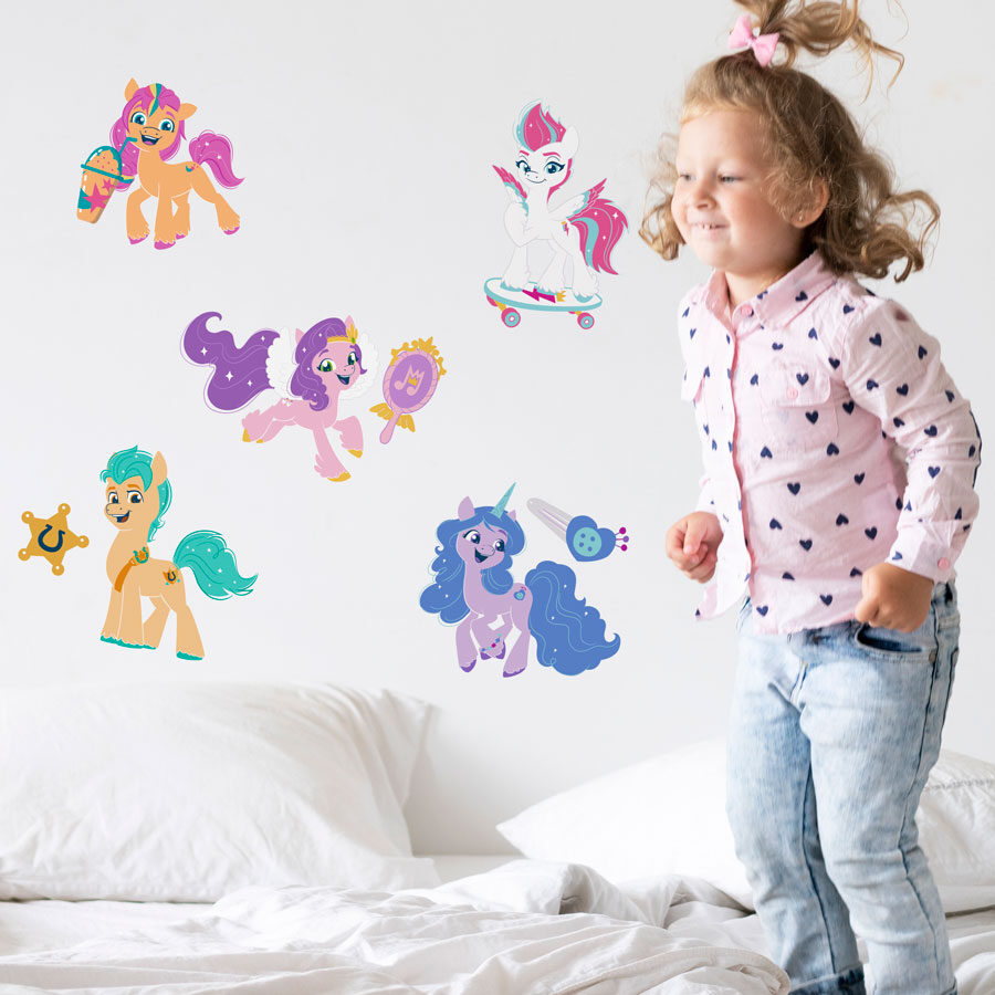 My Little Pony Sparkle Wall Sticker Pack shown on a white wall behind a child jumping on a white bed