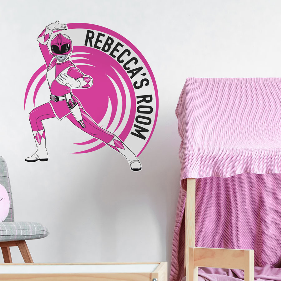 Personalised Rower Rangers wall sticker large pink shown on a white wall behind a grey chair and pink bed