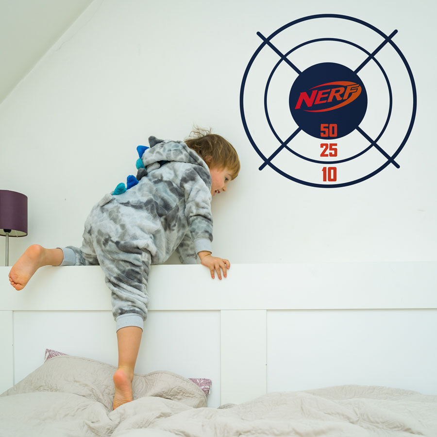 Nerf target wall sticker option 1 shown on a white wall behind a child climbing