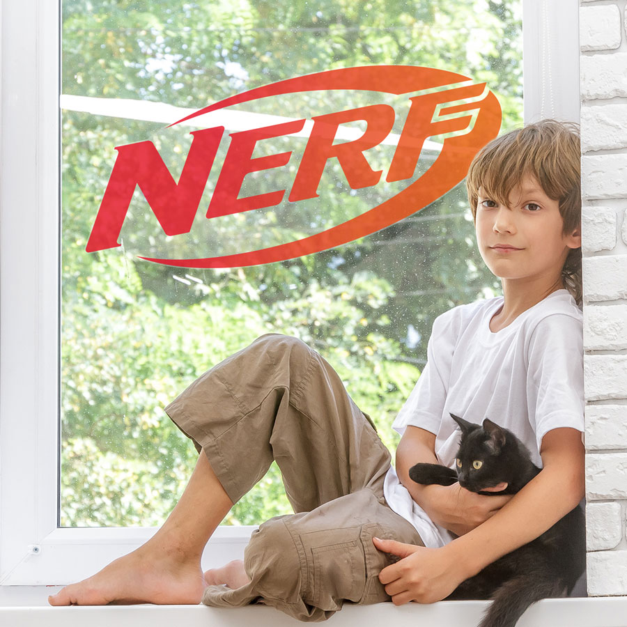 Nerf logo window sticker large shown on a window behind a child holding a cat
