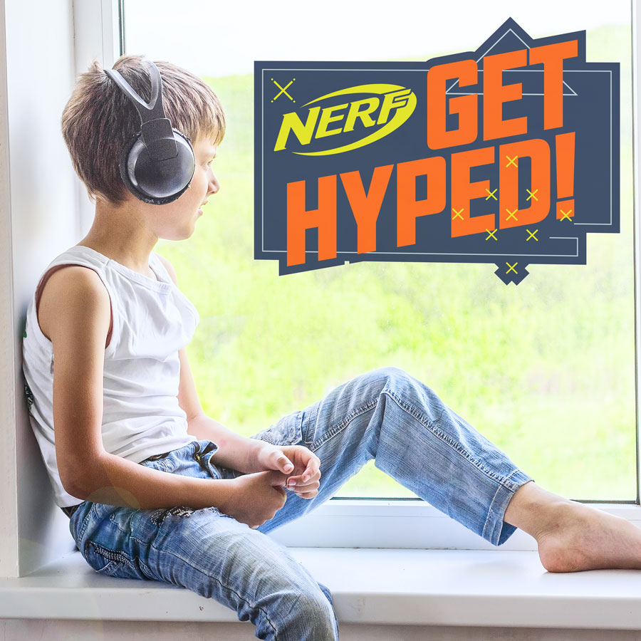Get Hyped! Nerf window sticker large shown on a window behind a child with headphones