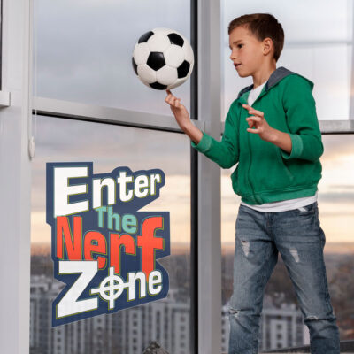Enter The Nerf Zone window sticker large shown on a window behind a child holding a football