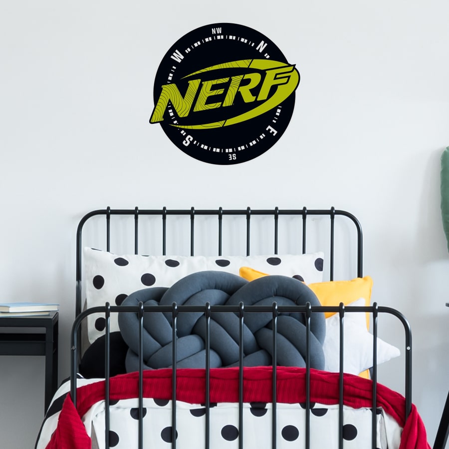 Nerf compass wall sticker large shown on a white wall behind a black bed with red, white and grey bedding