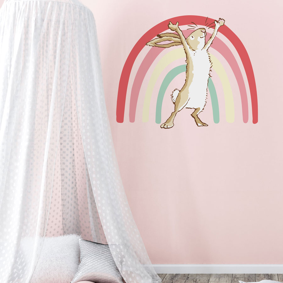 Rainbow hare wall sticker with no text large on a pink wall behind a white bed