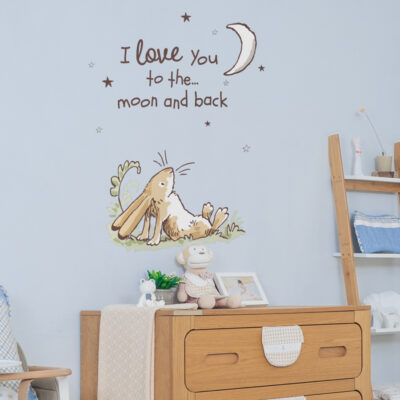 Moon & hare wall sticker large shown on a light blue wall behind a wooden dresser and ladder shelf