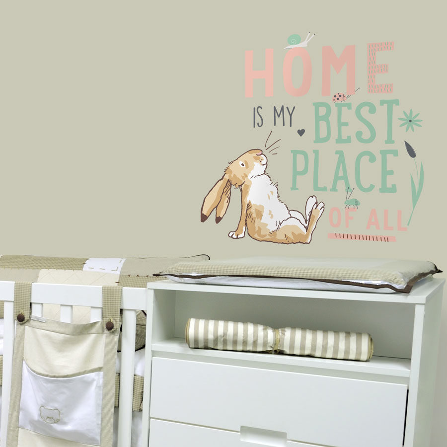 Best place of all wall sticker shown on a light beige wall behind a white dressing table and cot
