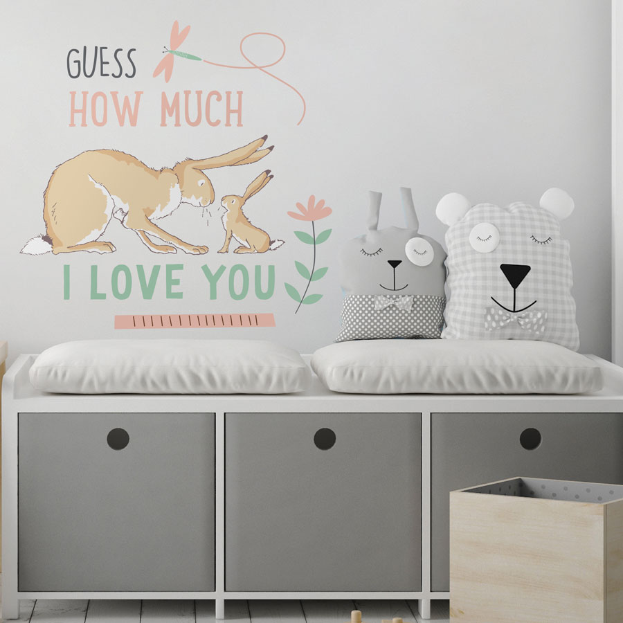 Guess How Much I Love You wall sticker shown on a light grey wall behind a white and grey storage bench