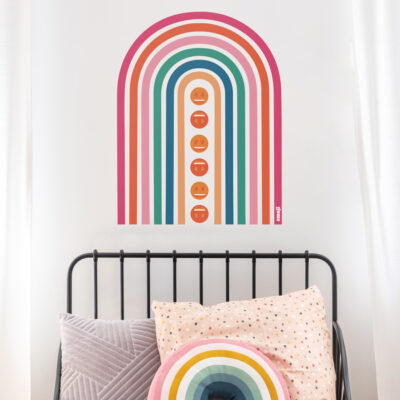 emoji rainbow wall sticker shown on a white wall behind a black bed frame with colourful pillows
