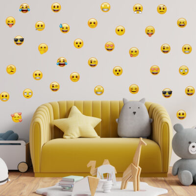 emoji Faces Wall Sticker Pack on a white wall behind a yellow sofa