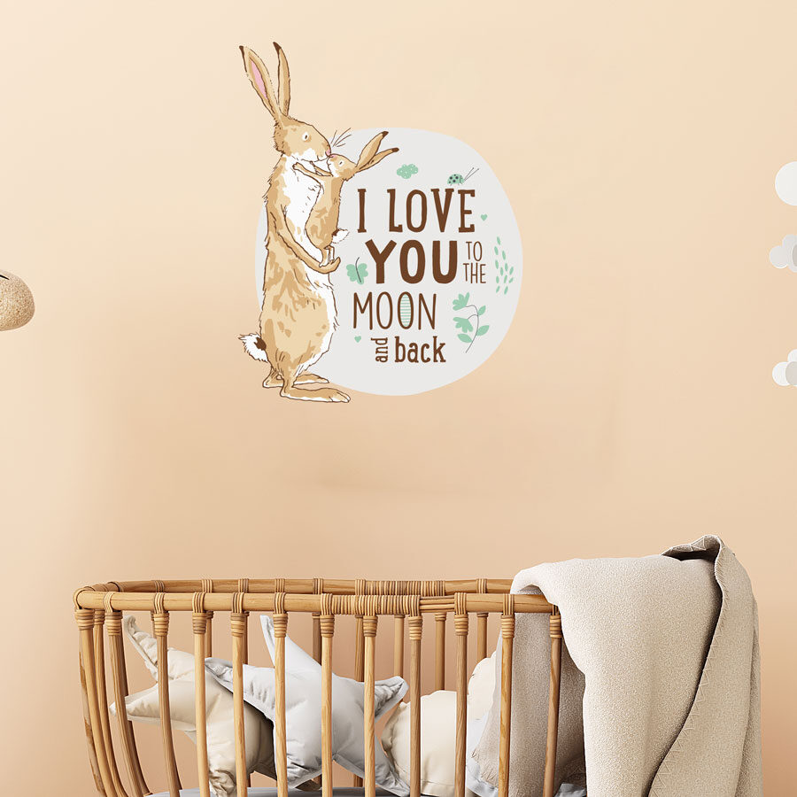 To the moon wall sticker option 2 shown on a light brown wall behind a wooden cot