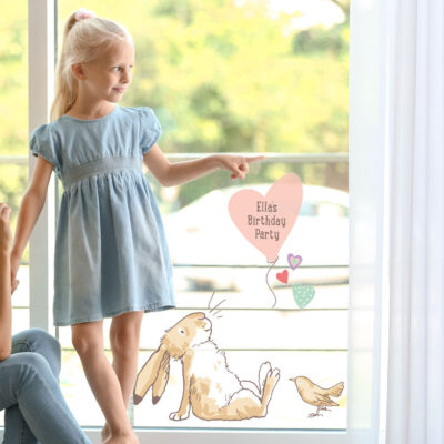 Personalised hare & balloon window sticker large shown on a window behind a young child pointing