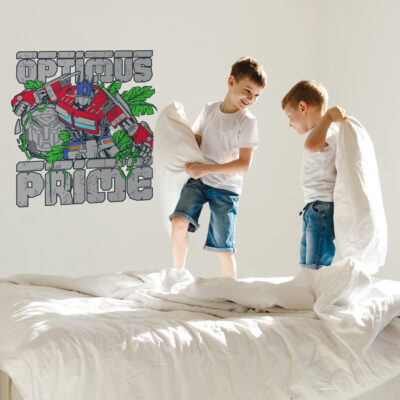 Optimus Prime wall sticker shown on a white wall behind children playing on a bed.