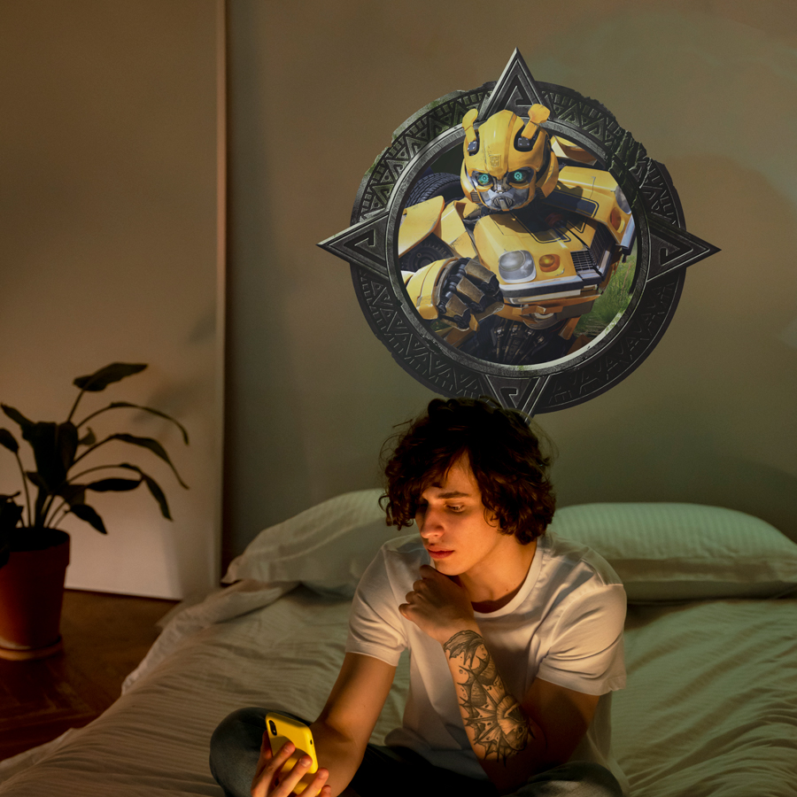 Bumblebee wall sticker shown on a cream wall above a child sat on a bed.