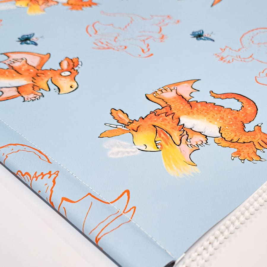 zog roller blind close-up showing dragon design on a light blue background with stitching across the bottom bar