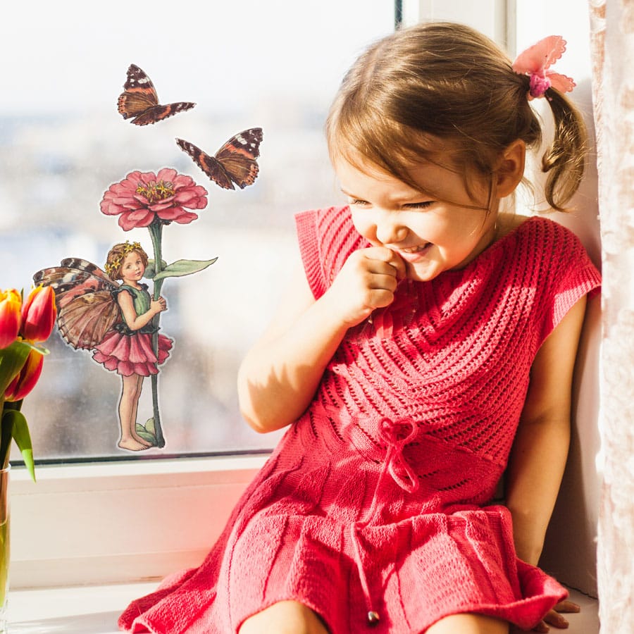The Zinnia Fairy window sticker on a window in front of a young girl