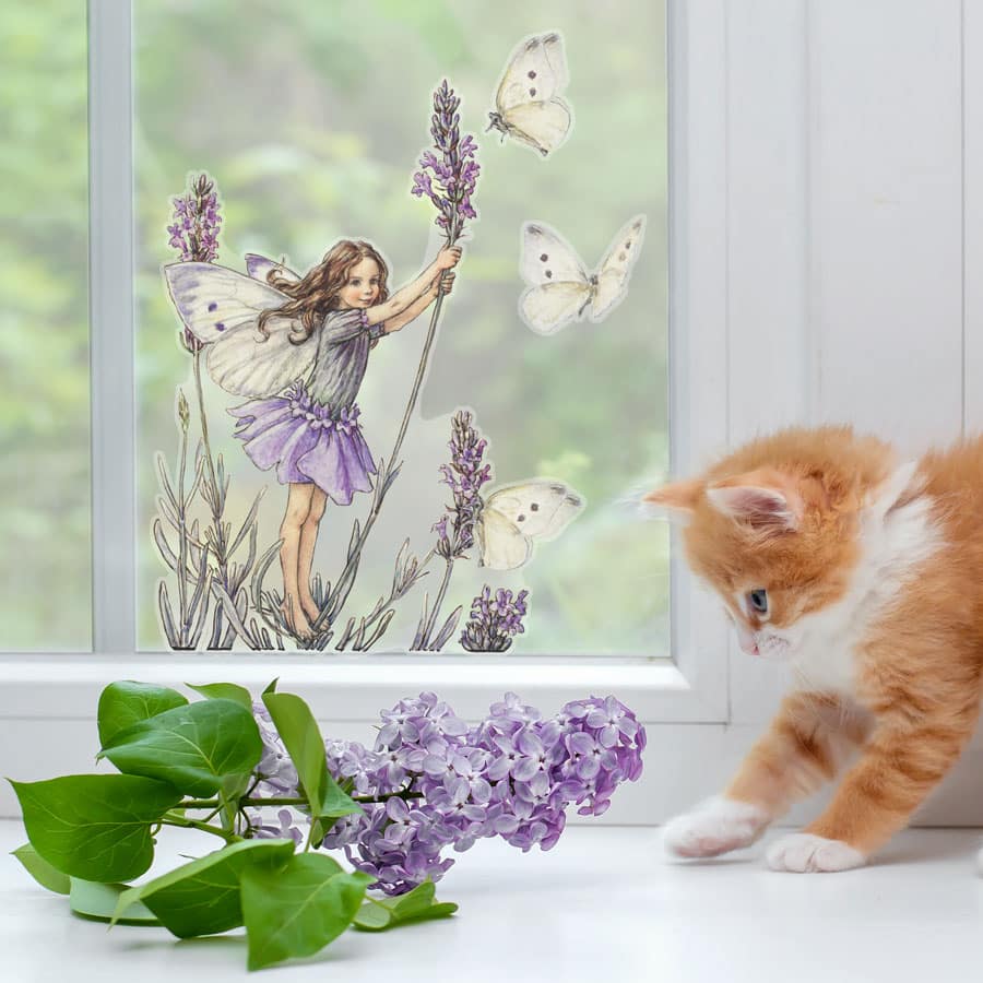 The Lavender Fairy Window Sticker on a window with cat and flowers