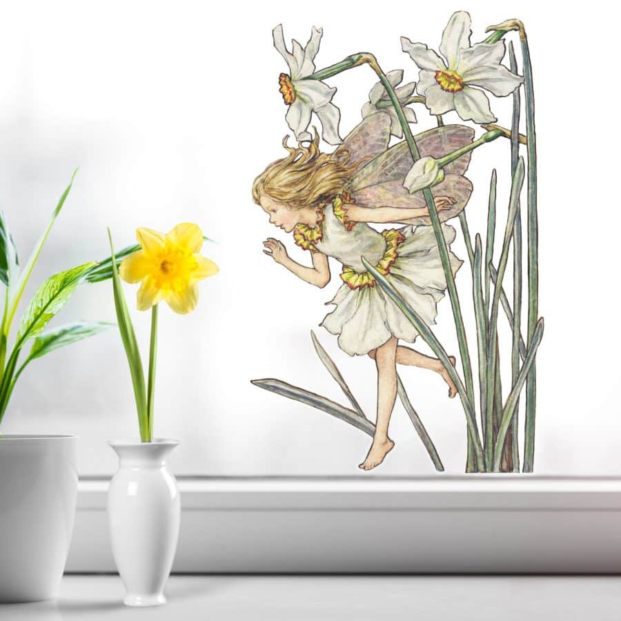 The Narcissus Fairy window sticker on a window next to a daffodil