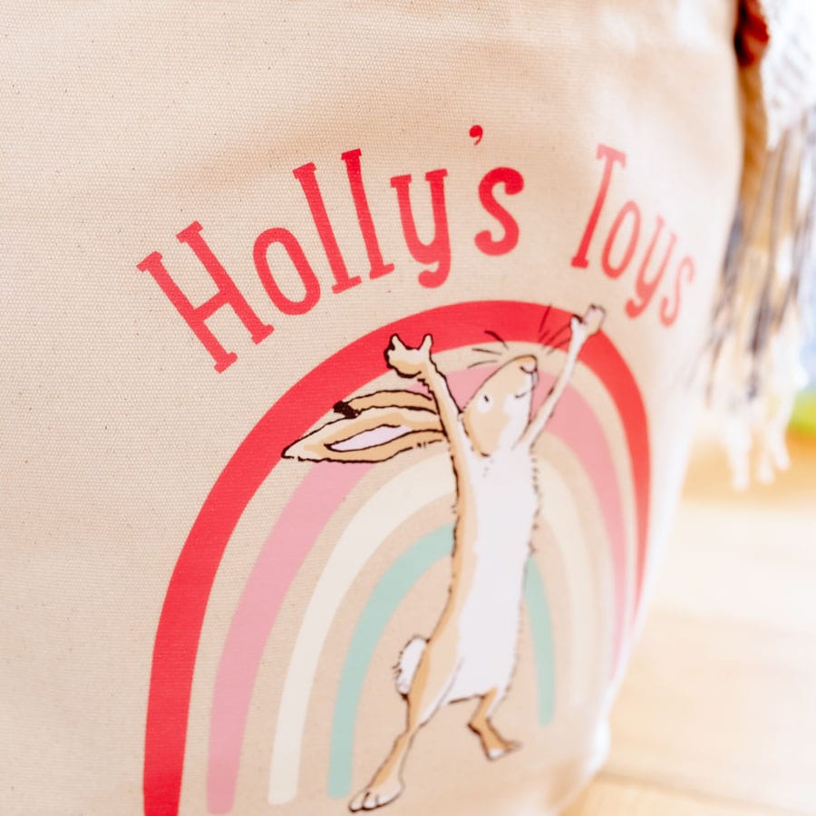 Close-up of a personalised Guess How Much I Love You soft storage basket, featuring Little Nutbrown Hare and rainbow design – ideal for nursery storage.
