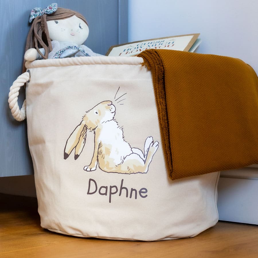 Guess How Much I Love You soft storage basket styled beside blue nursery furniture – perfect for storing toys, blankets or baby clothes.