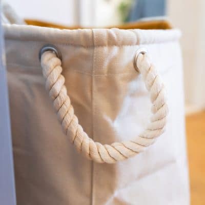 Detail of thick rope handle on a soft storage basket – made from natural cotton canvas for practical nursery storage.