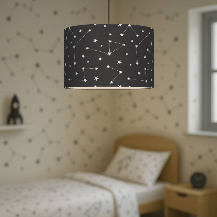 Dark constellation lampshade hanging in a child’s bedroom, styled with star and rocket-themed bedding and constellation wall decals.