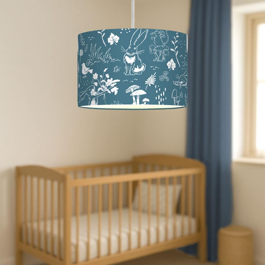 Blue Sketch Hares lampshade hanging above a natural wood cot in a nursery with blue curtains and calming neutral decor.