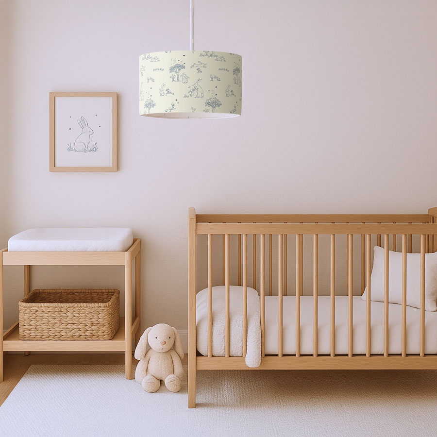 Cream toile hare lampshade hanging in a softly lit nursery with a wooden cot and changing table, styled with natural tones.
