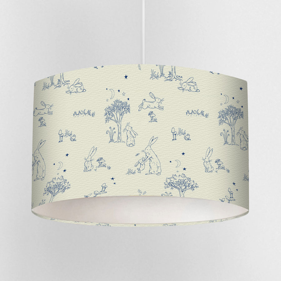 Close-up of cream toile lampshade featuring blue sketch-style illustrations of Little Nutbrown Hare and woodland scenes.