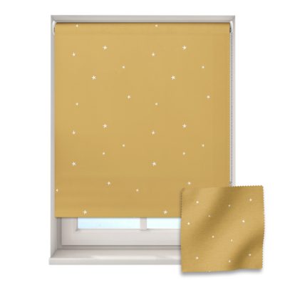 mustard stars roller blind on a window with a fabric swatch in front